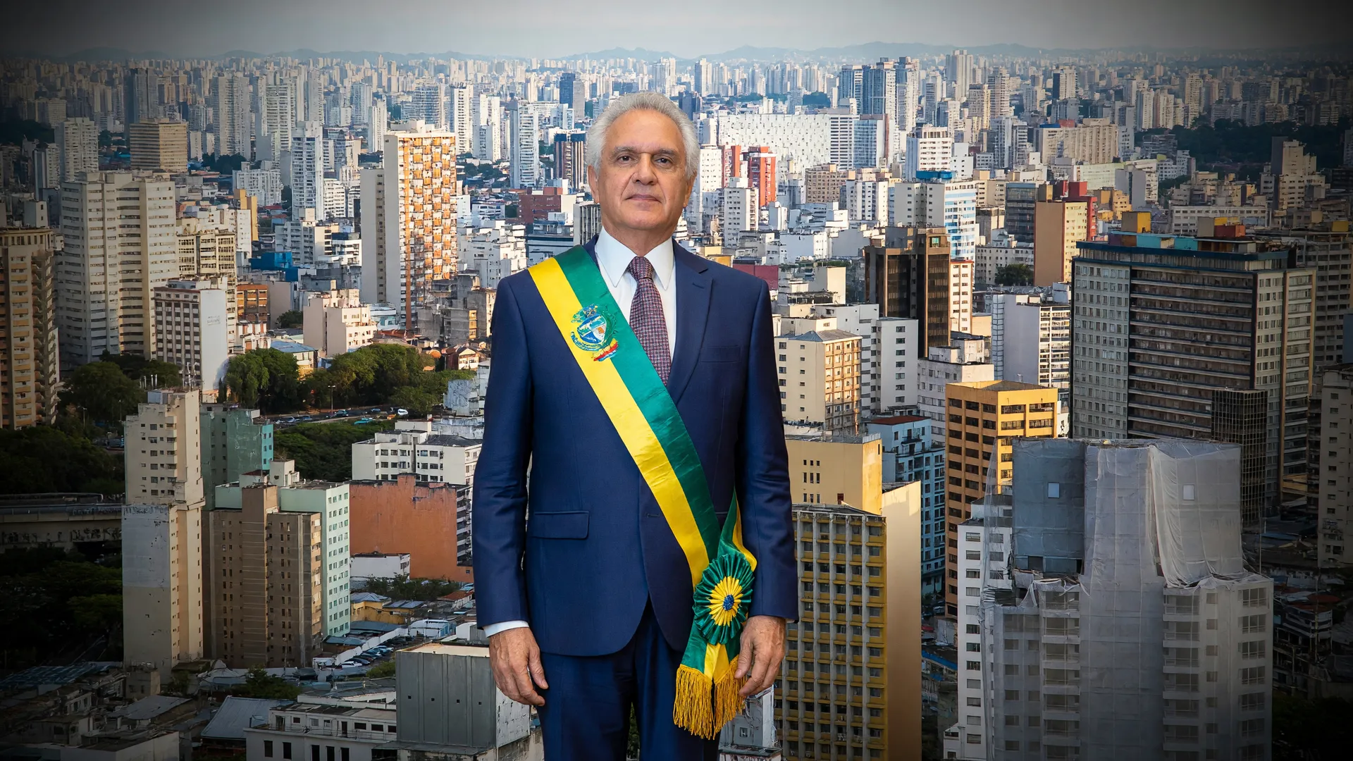 Ronaldo Caiado em traje oficial com skyline de São Paulo, representando sua candidatura à presidência em 2026
