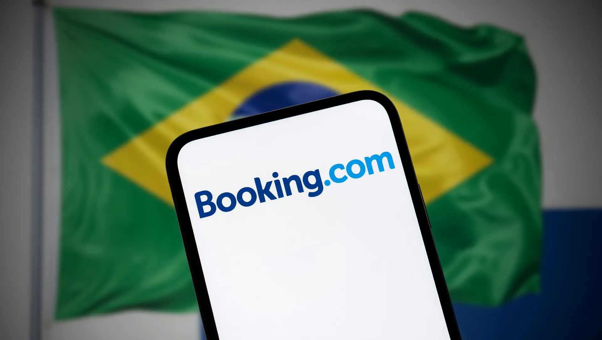 Booking.com vazamento dados pessoais clientes em ataque hacker. Smartphone compromete plataforma de viagens