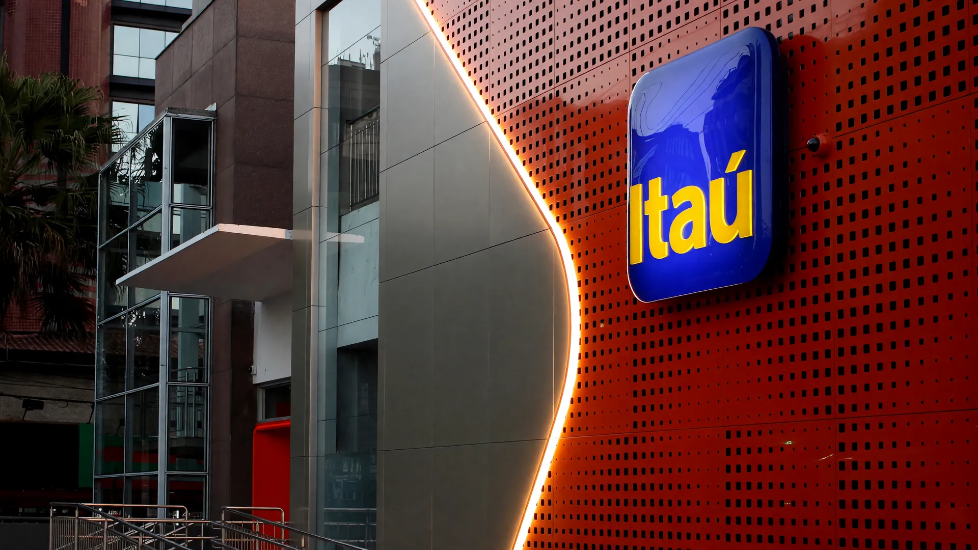 Fachada da agência Itaú com logo luminoso, símbolo da política de mais dias presenciais 2028