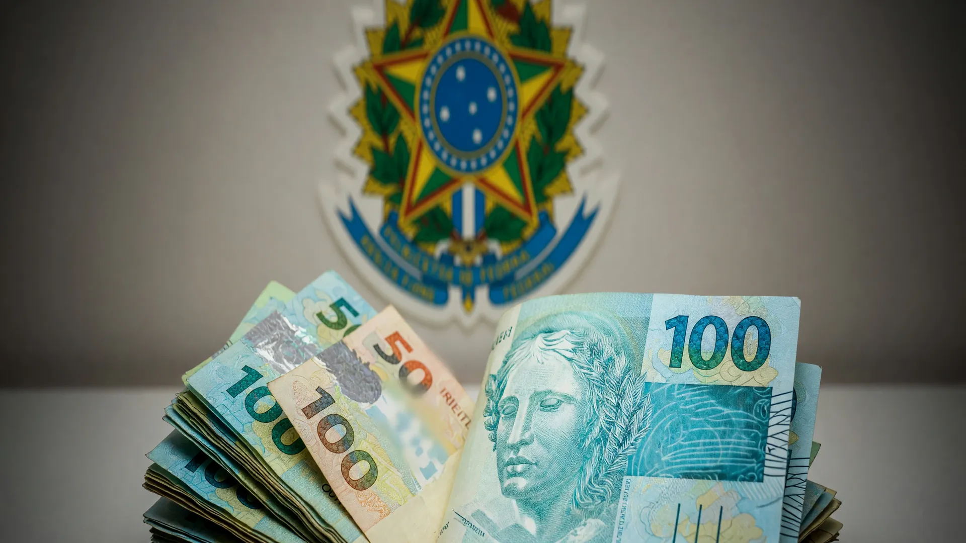 Símbolo da Receita Federal e cédulas de real ilustram o 3º lote restituição do IR aos contribuintes