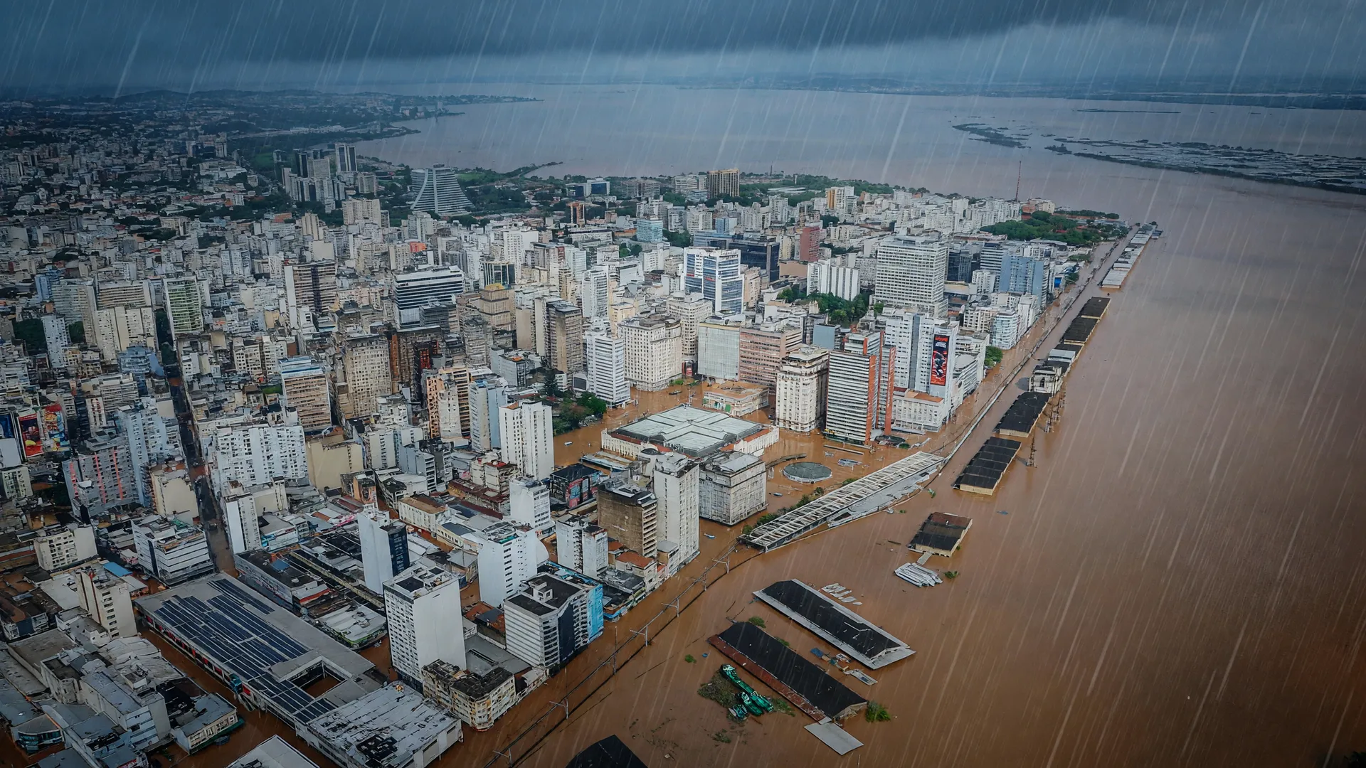 Aviso vermelho de tempestade: cidade alagada no Rio Grande do Sul sob céu escuro e chuva intensa