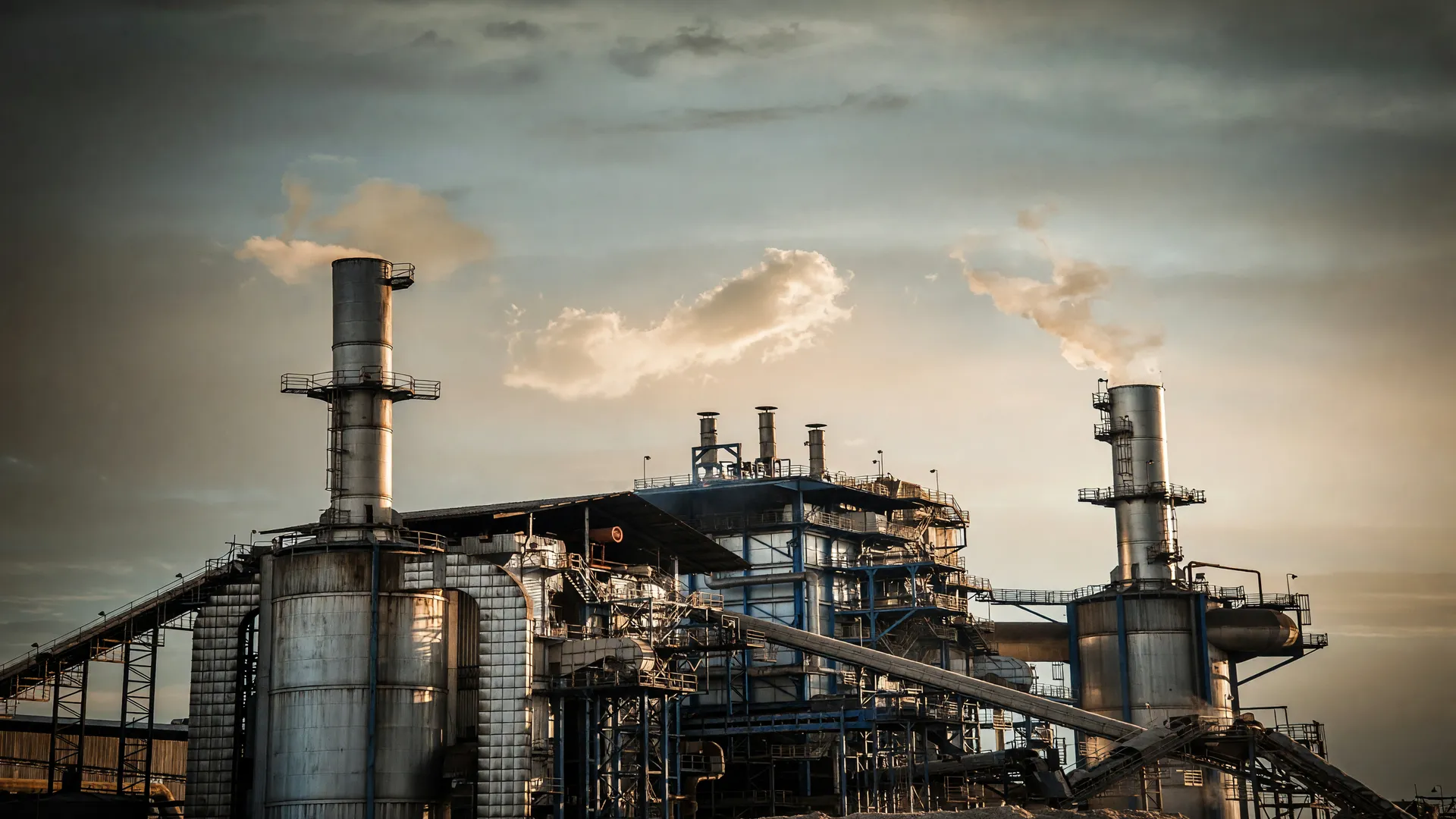 Chaminés industriais ao entardecer simbolizam queda na confiança da indústria brasileira