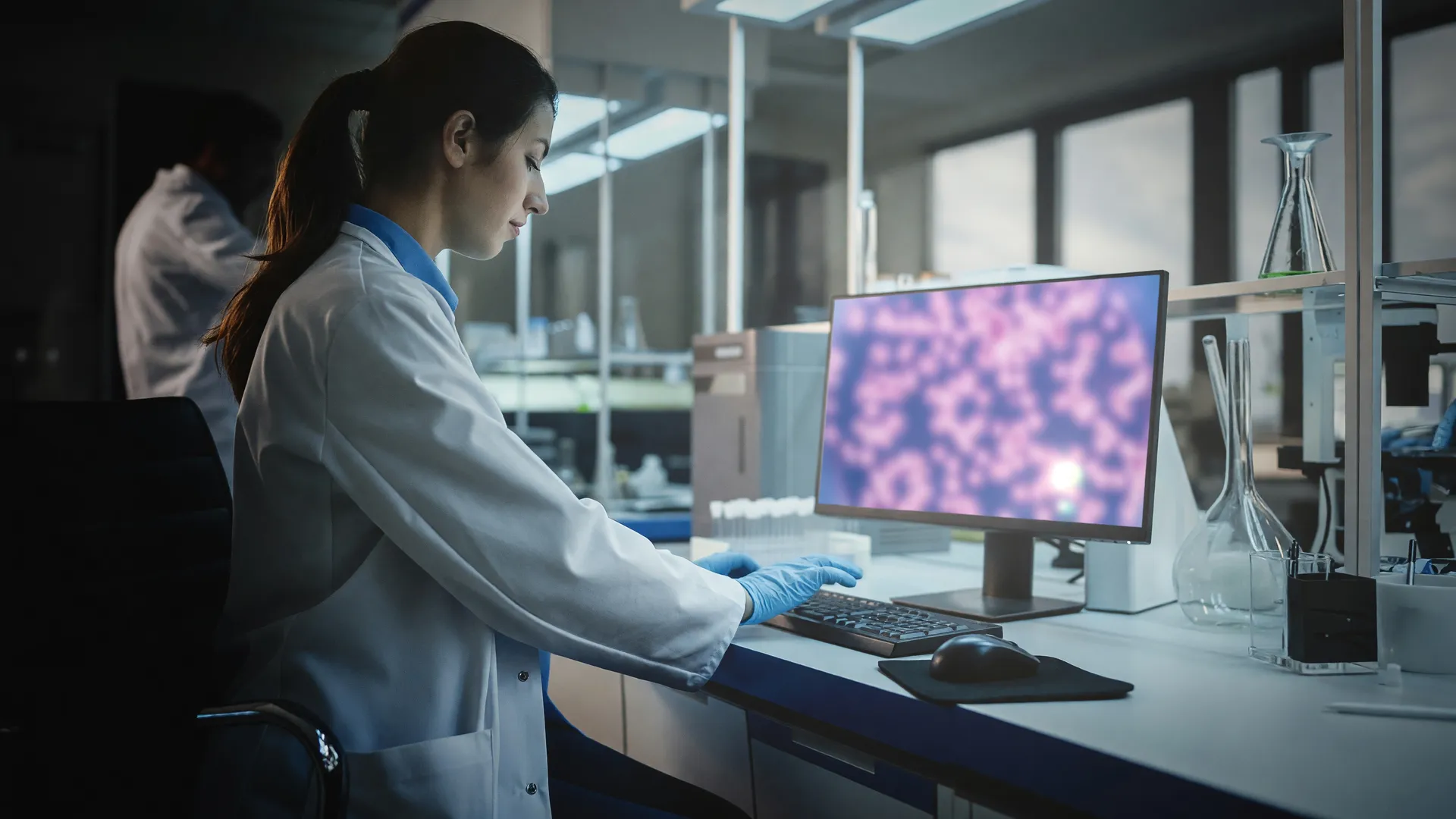Pesquisadora analisando dados genômicos em laboratório, representando inovação em diagnóstico câncer bucal sem biópsia