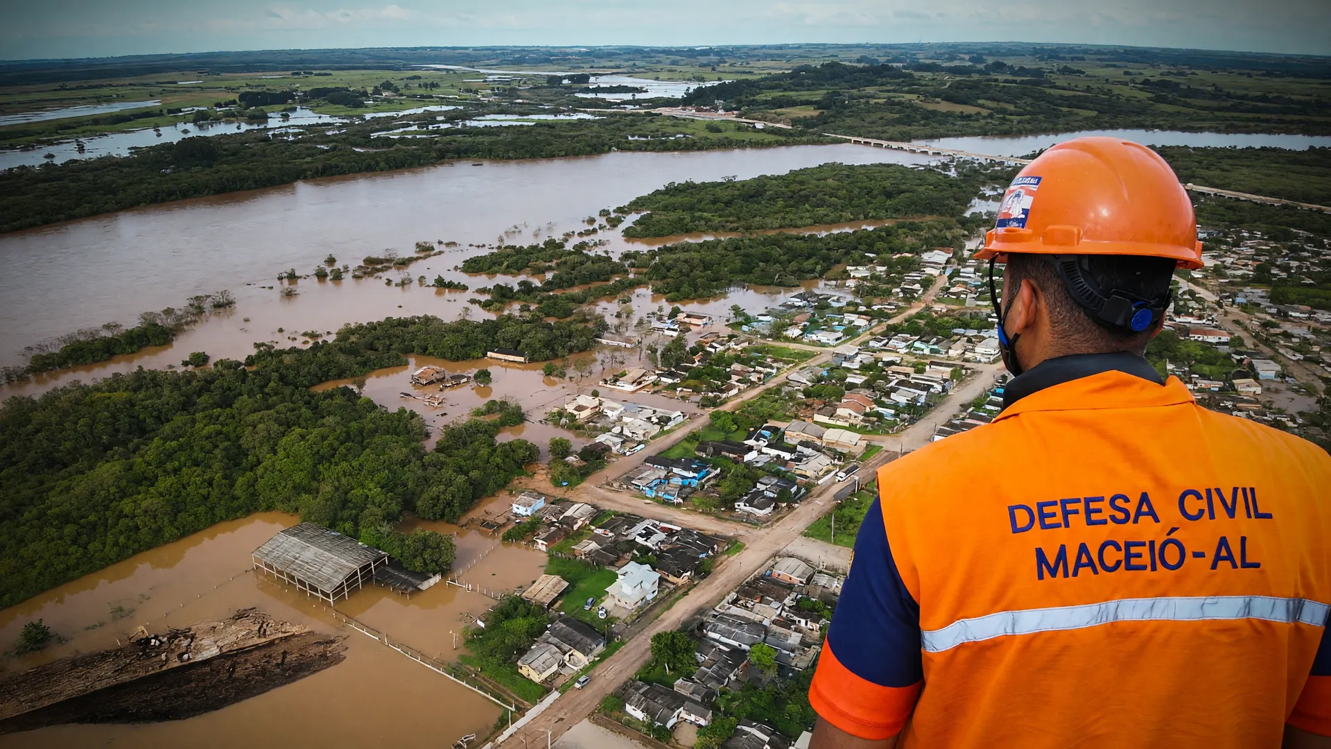 Defesa Civil atua em área alagada, destacando a urgência da prevenção a eventos climáticos extremos no Brasil.