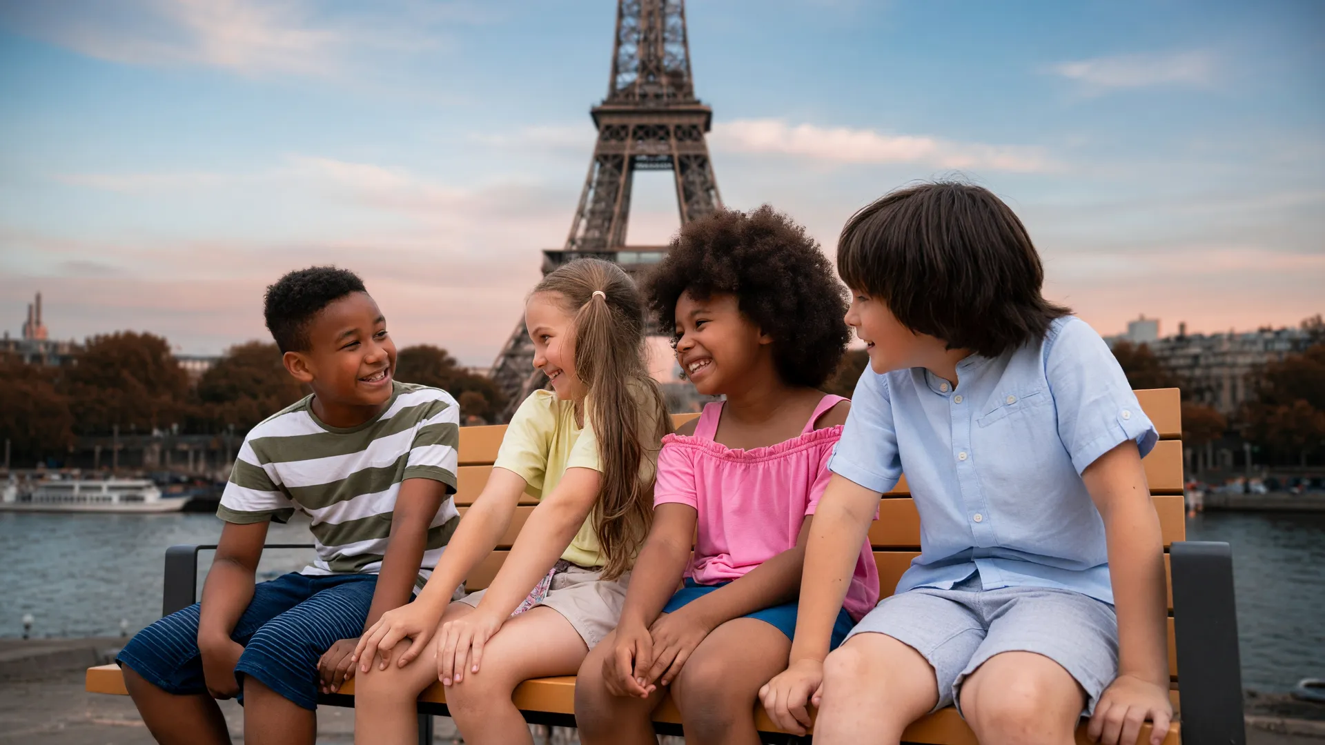 Crianças ao ar livre com a Torre Eiffel ao fundo, representando a proibição de redes sociais para menores na França