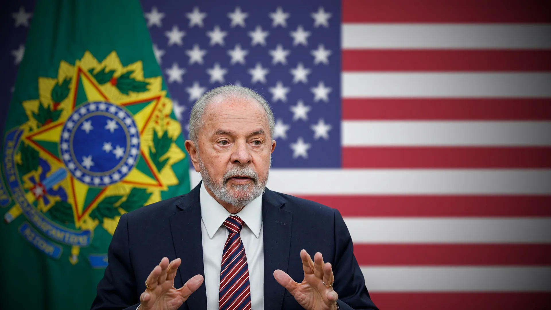 Lula em retrato oficial ao lado da bandeira dos EUA, simbolizando a tarifa dos EUA no Brasil no comércio bilateral.