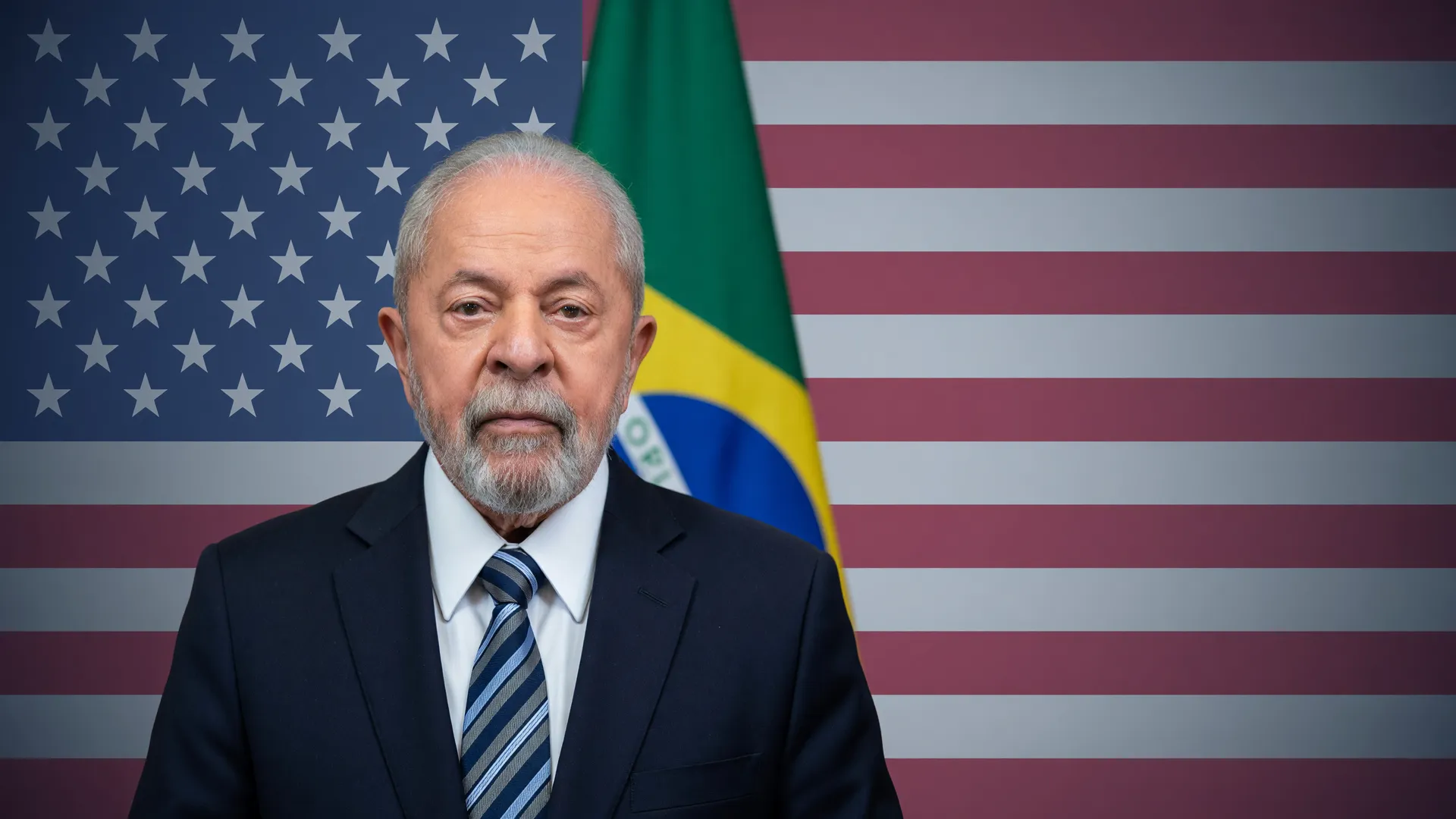 Lula em retrato oficial ao lado da bandeira dos EUA, simbolizando o tarifaço de 25% dos EUA contestado pelo Brasil