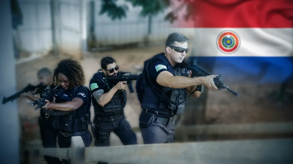Equipe policial em operação de combate a anabolizantes falsificados no Brasil, com bandeira do Paraguai ao fundo