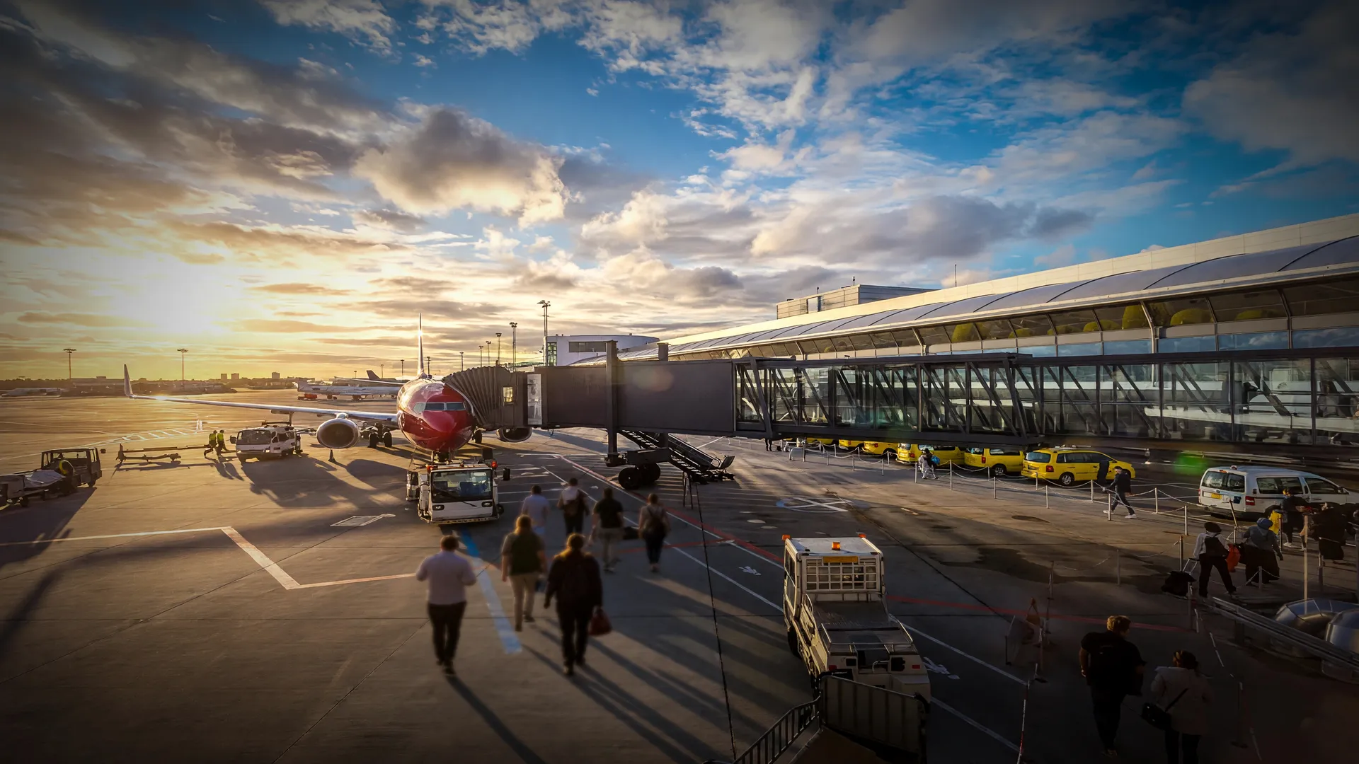 Passageiros embarcando em aeroporto ao entardecer, evocando a nova política de biometria em aeroportos e portos