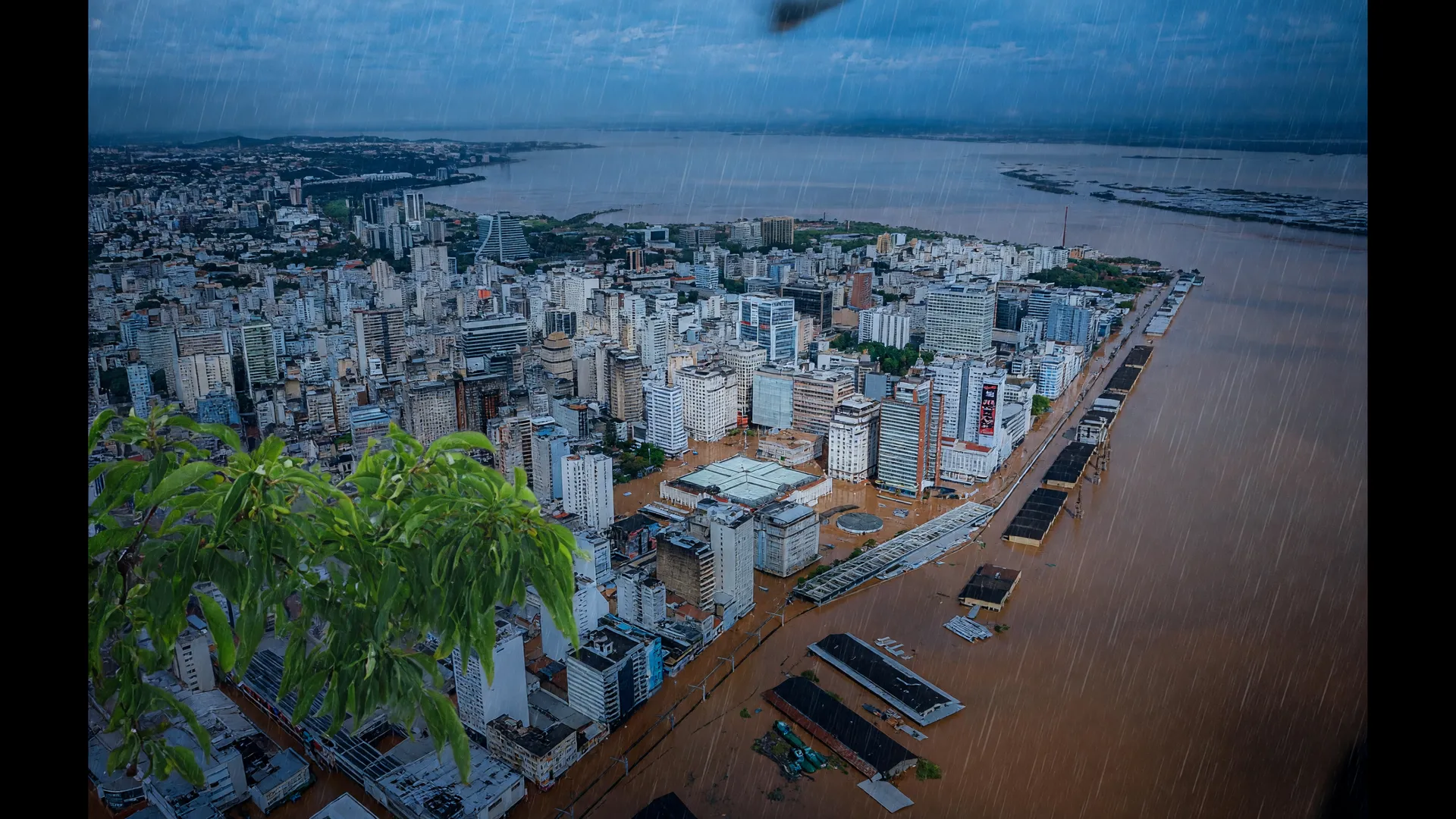 Vista aérea de cidade inundada no RS sob chuva torrencial, ilustrando a ameaça do ciclone extratropical no Sul
