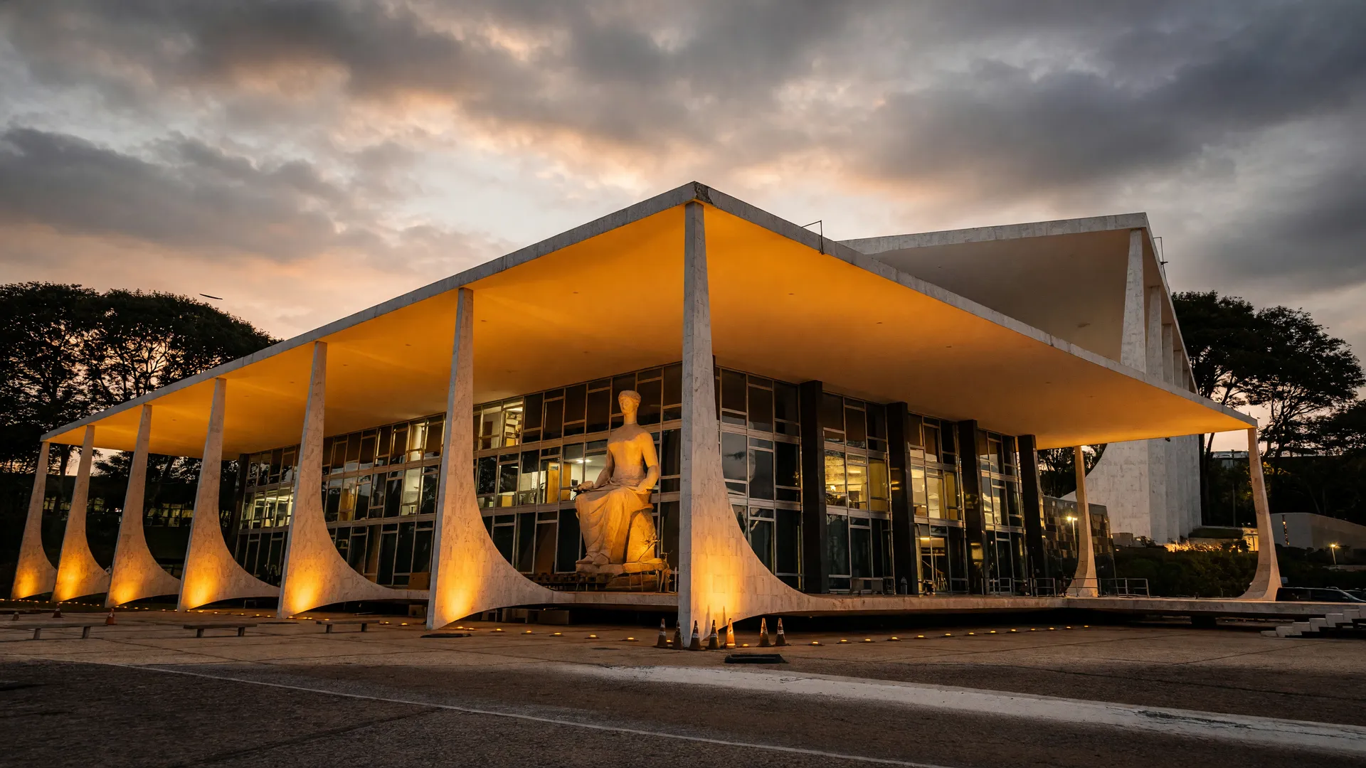 Escultura da Justiça em frente ao STF ao entardecer, símbolo da polêmica gratificação para assessores do STF