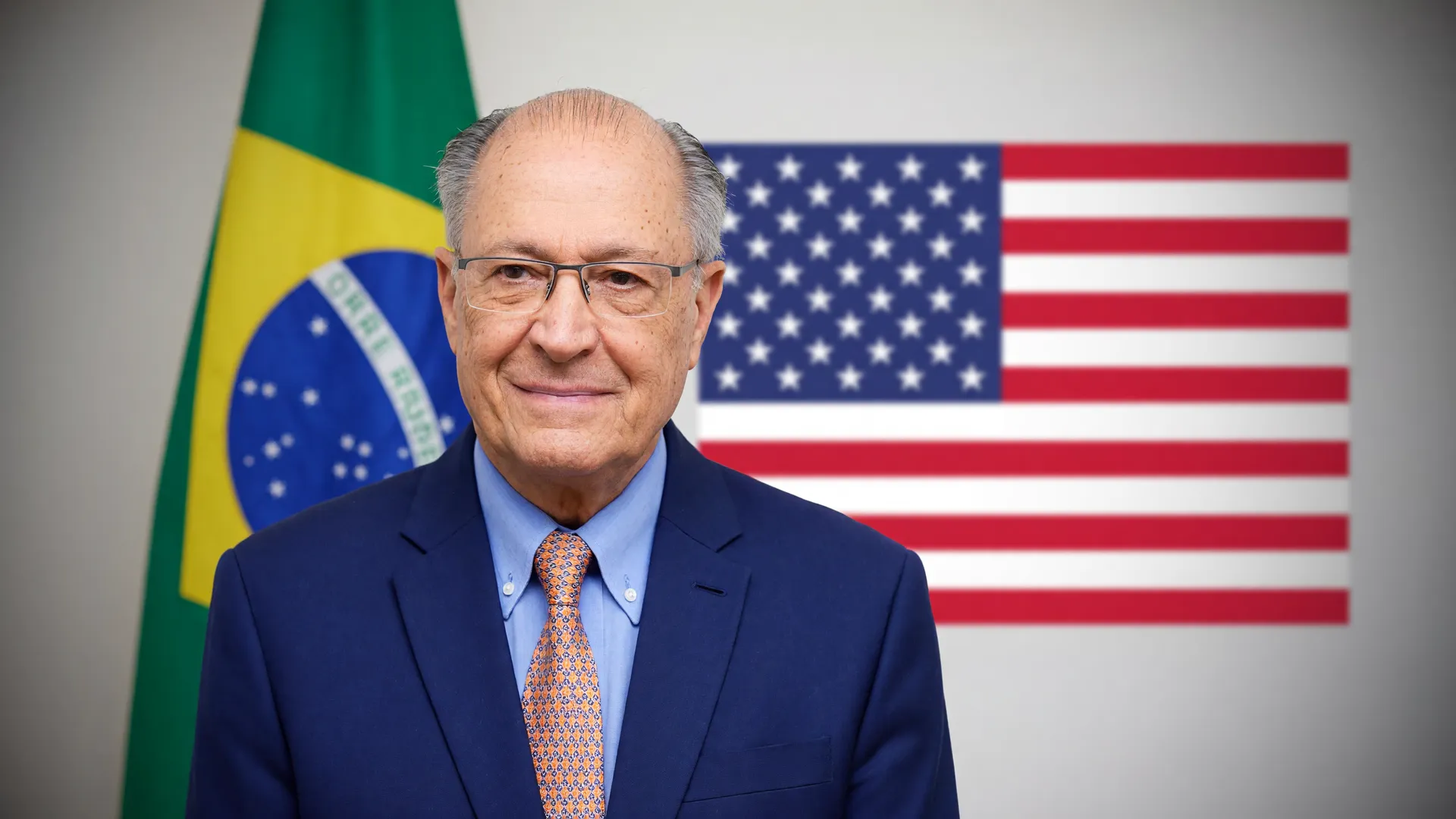 Alckmin em postura oficial com bandeira dos EUA ao fundo, representando a negociação tarifaço EUA Brasil