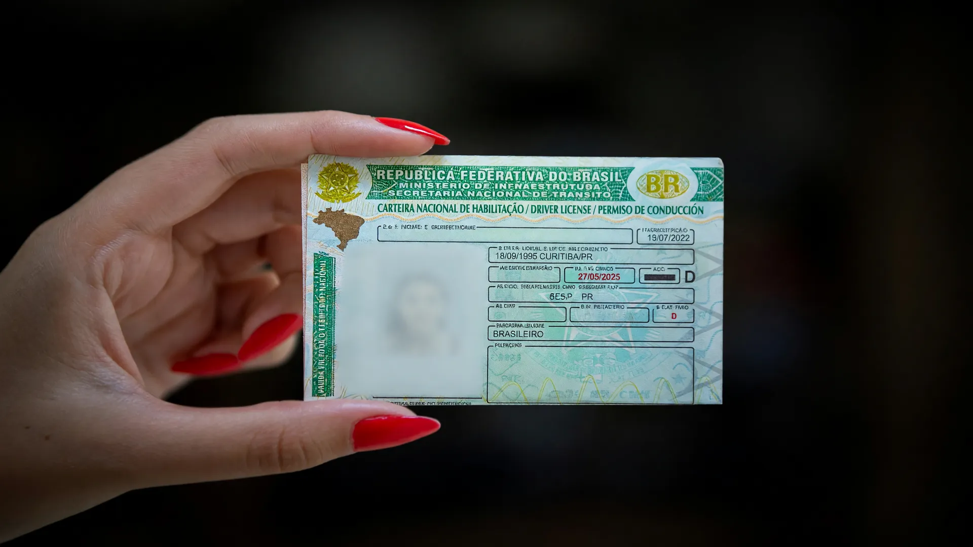 CNH em mão feminina — nova regra da lei seca exige pré-teste antes do bafômetro para álcool e drogas