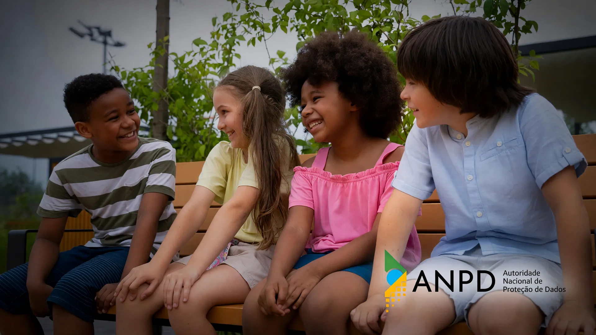 Estudantes reunidos ao ar livre com logotipo da ANPD, tema do reconhecimento facial em escolas suspenso no Paraná
