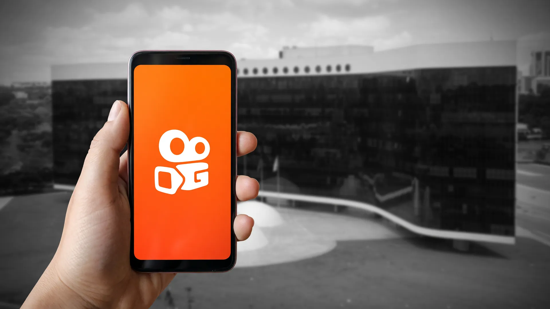 Smartphone com o app Kwai em primeiro plano e o TSE ao fundo, simbolizando fiscalização dos anúncios eleitorais no Kwai