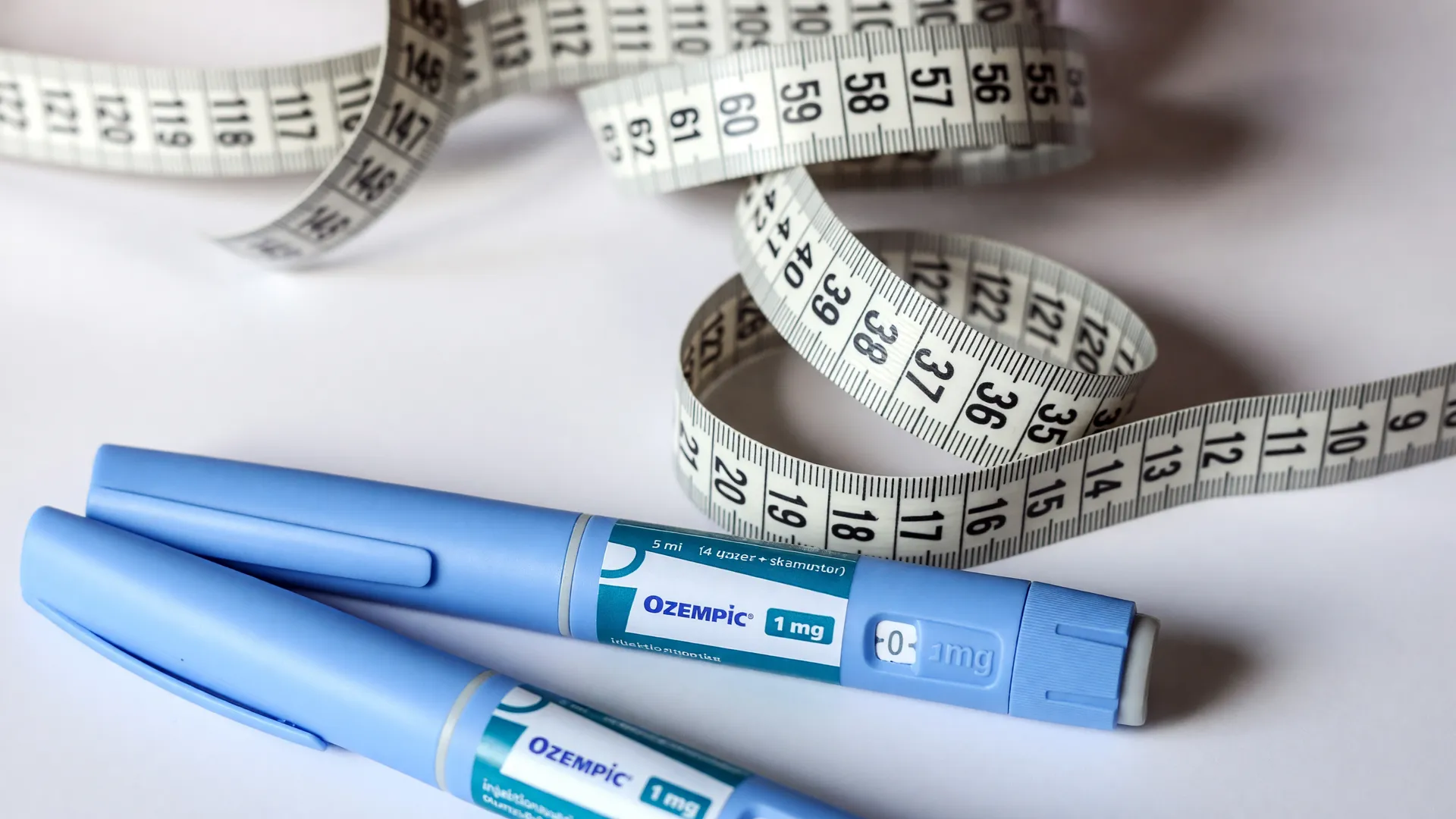 Canetas emagrecedoras sem prescrição médica cercadas por fita métrica, com adolescentes desfocados ao fundo