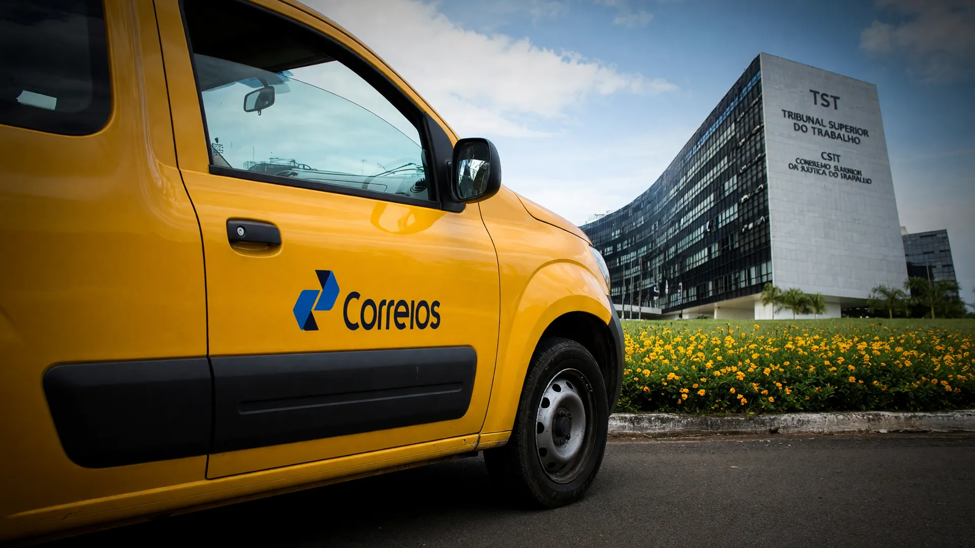 Veículo dos Correios parado e sede do TST ao fundo, simbolizando o impasse da greve dos Correios plano de saúde