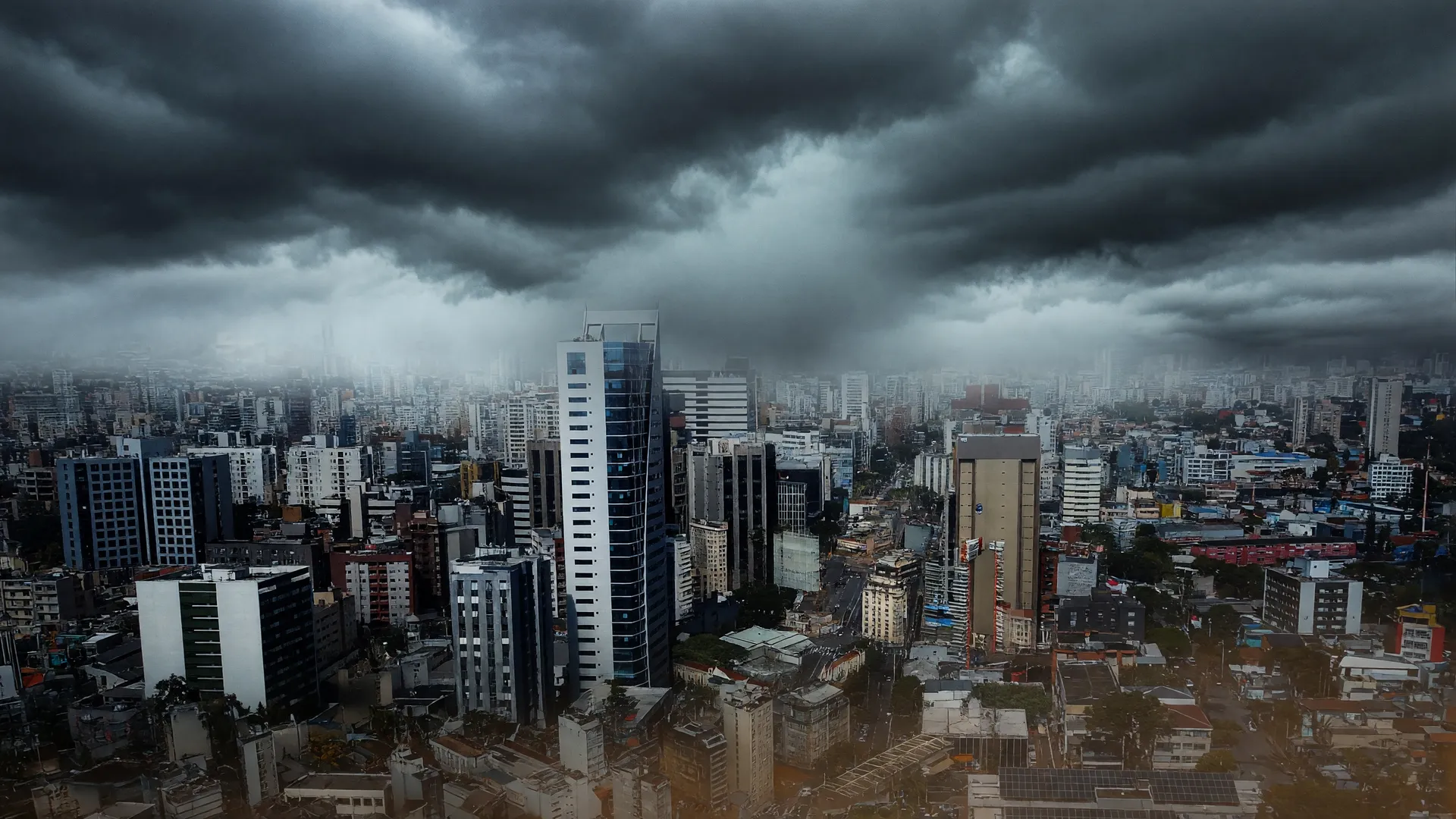 Vista aérea de Curitiba com céu tempestuoso evocando tornados no Sul do Brasil e a devastação de eventos extremos