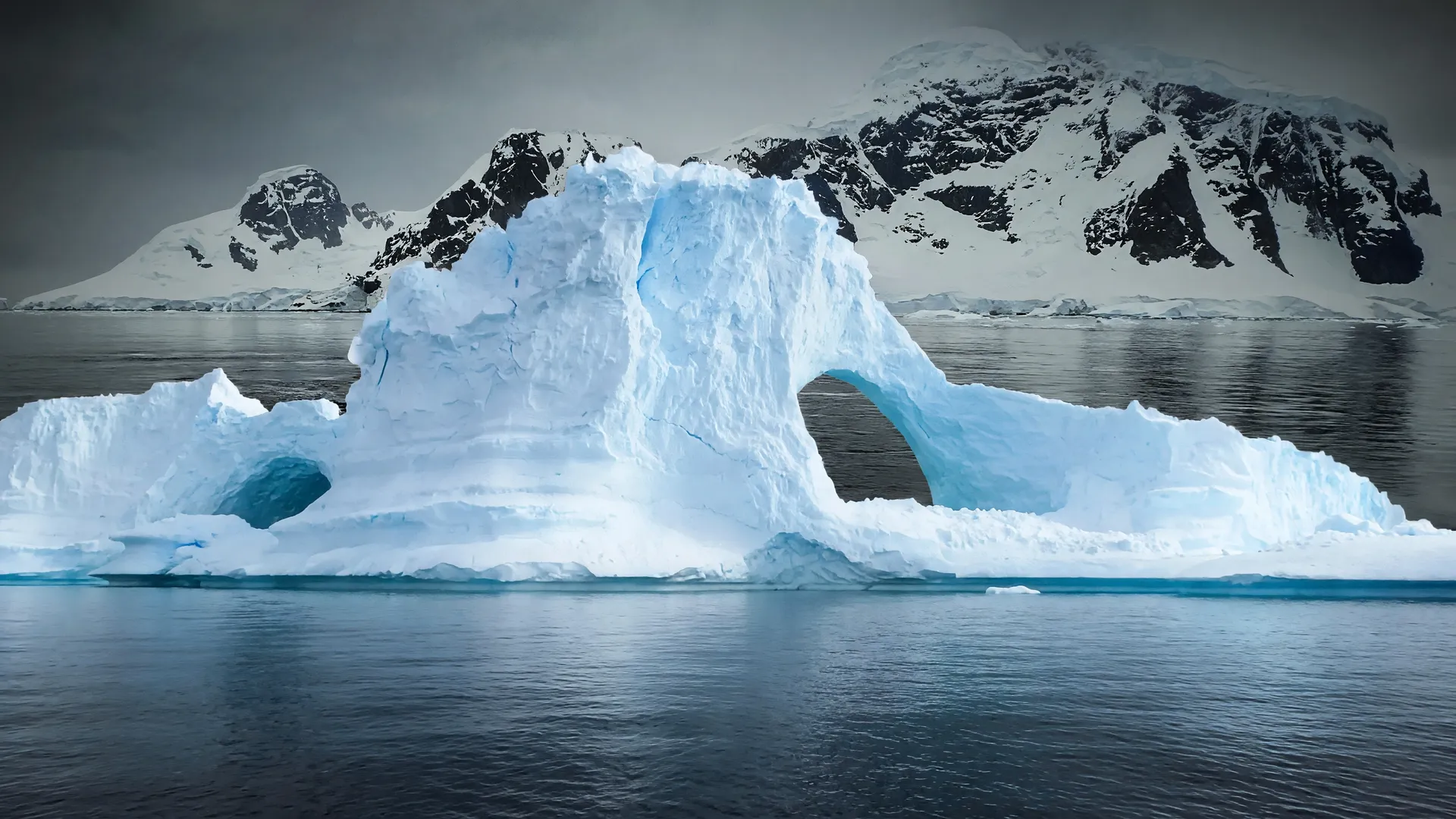 Iceberg antártico erodido em águas calmas, ilustrando o risco da geleira Thwaites nível do mar subir até 2100
