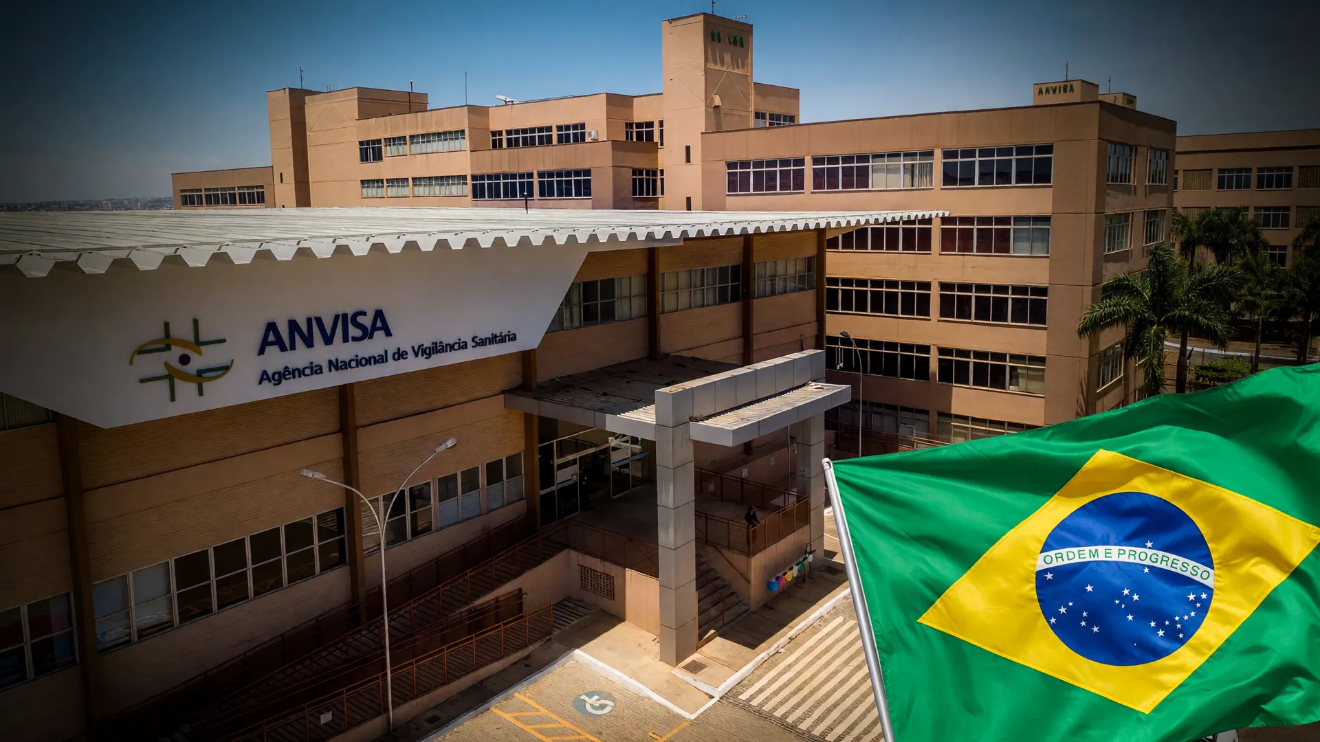 Sede da Anvisa com bandeira do Brasil ao fundo, simbolizando a espera por novo remédio para Parkinson no país.